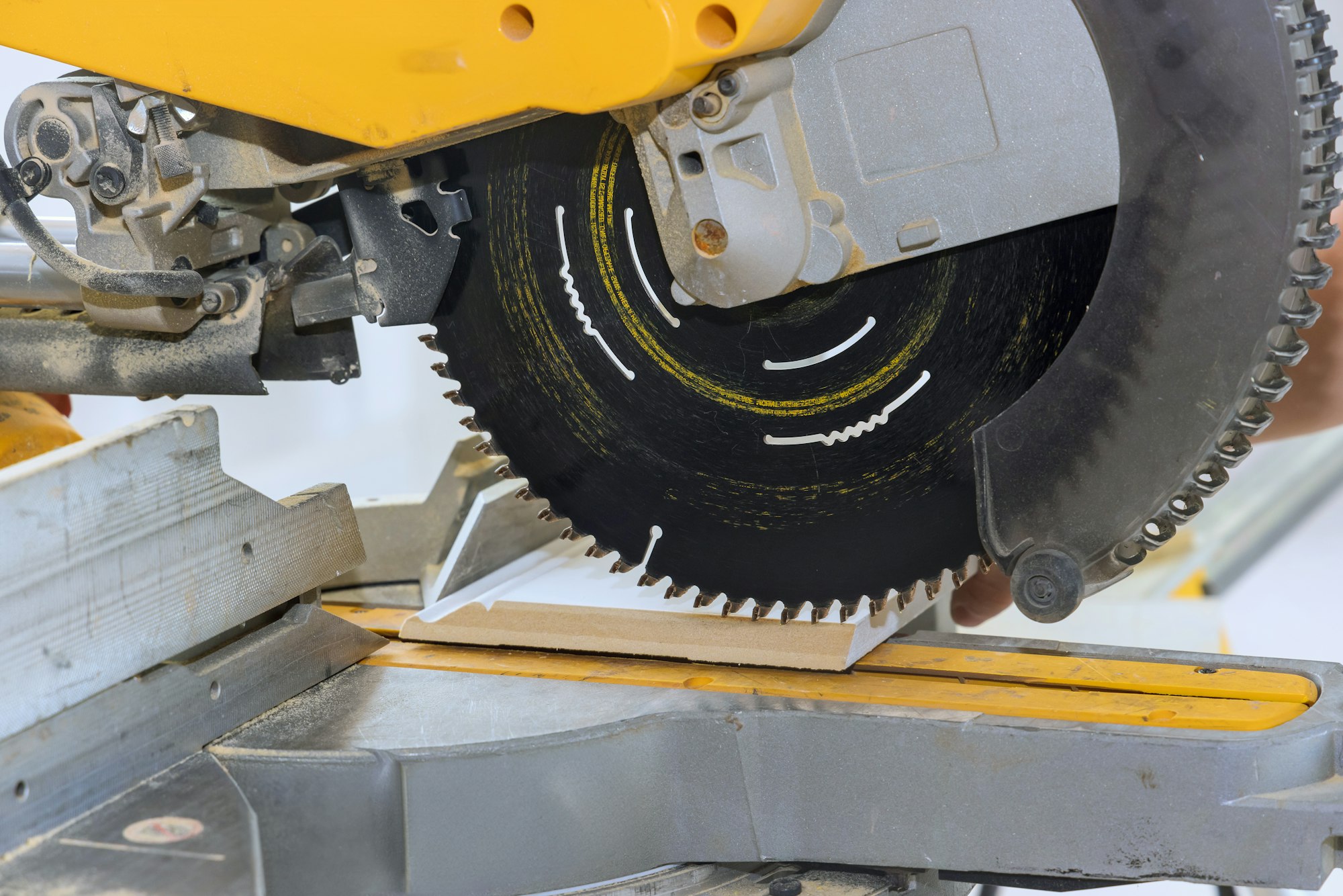 Chop saw is used to cut wooden base moldings of a house improvement project